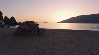 Tropikal adada güzel bir gün batımı ve kumlu bir plaj..