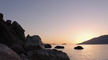 Tropik adanın kayalık sahillerinde gün batımı. Manzaralı vahşi doğa manzarası.