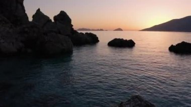 Gün batımında denizde kaya oluşumu. Cennet adası tatili.