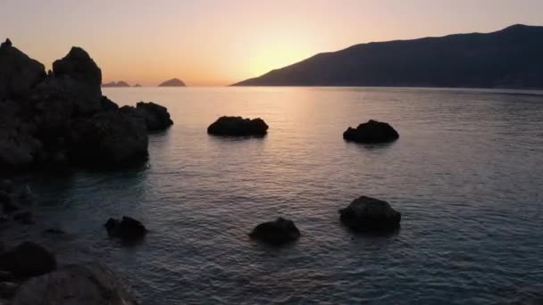 Costa tropical rocosa al atardecer. Océano y montañas bajo el cielo rojo de la noche. — Vídeo de stock