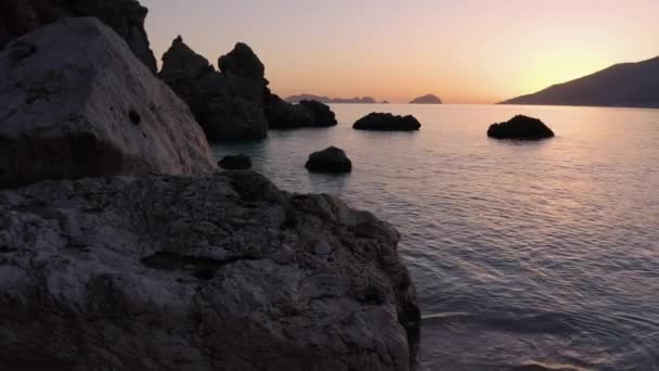 Ontspannende oceaangolven en enorme rotsen op tropisch strand bij zonsondergang. — Stockvideo