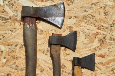 Ahşap arka planda tahta saplı iş baltaları..