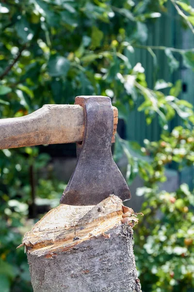 Ax in einem Baumstamm auf dem Hintergrund des grünen Grases. — Stockfoto