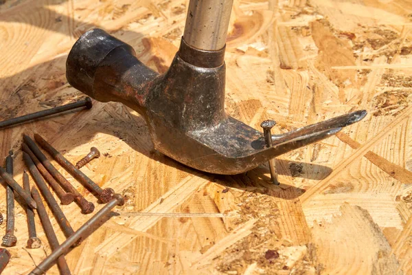 Großaufnahme alter rostiger Hammer mit langen metallischen Nägeln. — Stockfoto