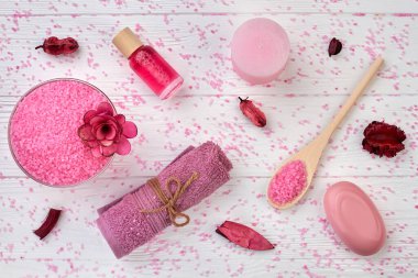 Düz pembe spa aksesuarları beyaz ahşap masanın üzerinde yatıyordu..