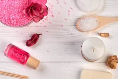 Beyaz ahşap masaya çeşitli banyo spa aksesuarları serilmişti..