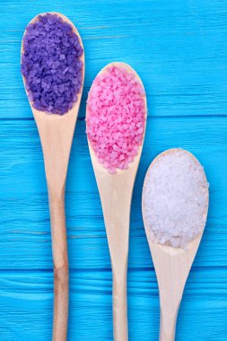 Çok renkli tuz tanecikleriyle dikey çekim kaşıkları.