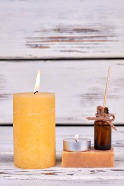 Dikey çekim sabun ve yağla yanan sarı mum.