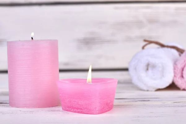 Розовые круглые горящие свечи с катанными полотенцами. — стоковое фото