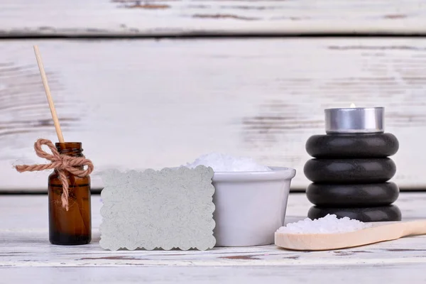 Body oil bottle with stones and spoon for spa treatment.