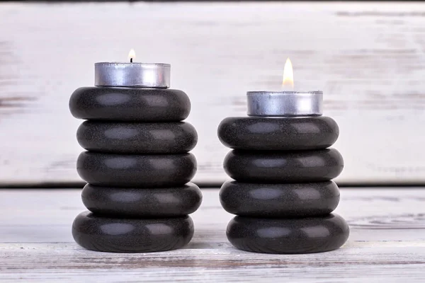 Stapel schwarzer Steine mit Kerzen für die Wellnesstherapie. — Stockfoto