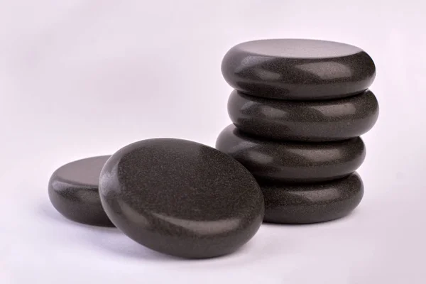 Piedras negras pulidas para terapia de tratamiento de spa sobre fondo blanco. — Foto de Stock