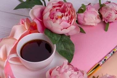 Gül çiçekli ve kalemli bir fincan çay..