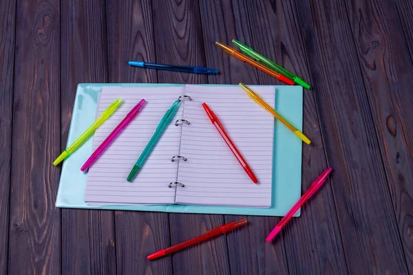 Visão superior bloco de notas aberto com muitas canetas. — Fotografia de Stock