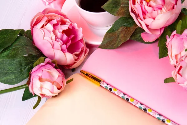 Close-up fiori di rosa con penna e tazza di caffè. — Foto Stock