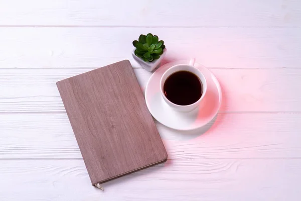 Journal de bord avec tasse de café ou de thé et plante. — Photo