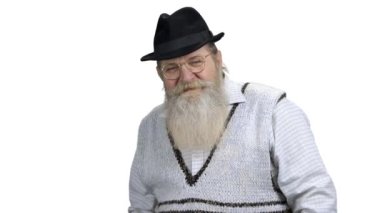 Sakallı adam beyaz arka planda kamerayla konuşuyor..