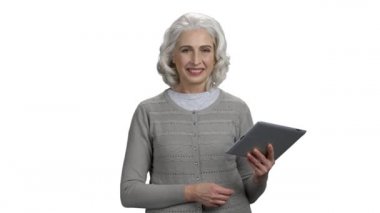 Beyaz arkaplanda bilgisayar tableti olan olgun bir kadın.