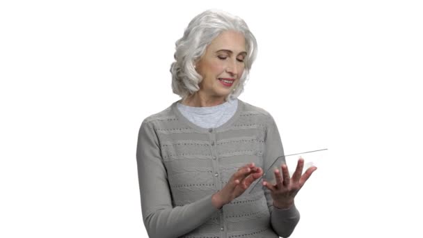 Grijsharige vrouw die futuristische glazen tablet gebruikt. — Stockvideo