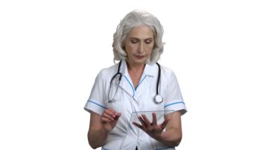 Beyaz arkaplanda cam tablet kullanan olgun bir doktor..