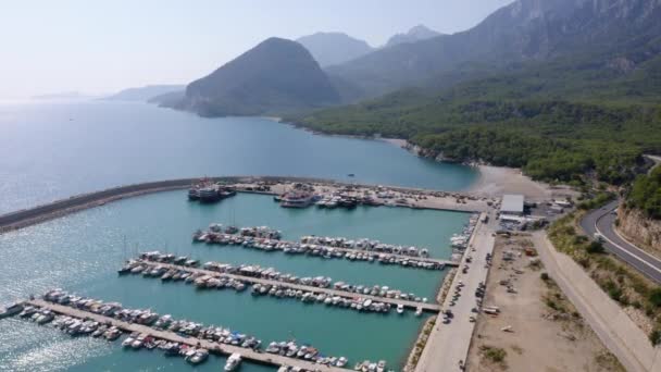 Вид с воздуха на лодки в гавани в морской бухте. Горная дорога вдоль морского побережья. — стоковое видео