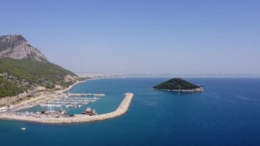 Turkuaz okyanus deniz manzarası. Deniz kıyısındaki liman ve dağ yolu.