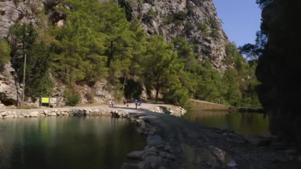 Schöne Landschaft mit riesigen Felsen und Touristen, die an einem Sommertag im Bergpark mit See spazieren gehen. — Stockvideo