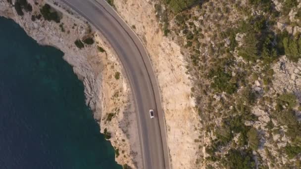 Scénický letecký pohled na horskou silnici s řidičským autem v blízkosti modrého moře. — Stock video