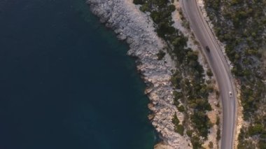 Denize ya da okyanusa yakın dağ yolunda hızla giden araçlar..