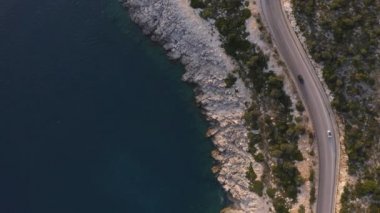 Deniz kenarındaki güzel dağ yolunun havadan manzarası. Yukarıdan araba trafiği.