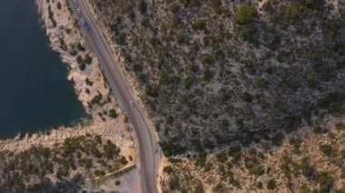 Dağlar ve mavi okyanus boyunca otoban manzarası.