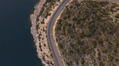 Kayalık sahildeki dağ yolundan geçen araçların hava görüntüsü..