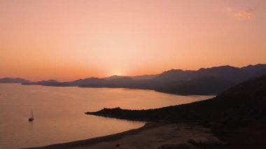 Deniz ve dağların üzerinde güzel kızıl gün batımı. Havadan panoramik görünüm.
