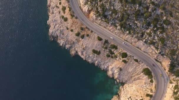 Vue aérienne de la route serpentine près de la montagne verte et de la mer bleue. — Video