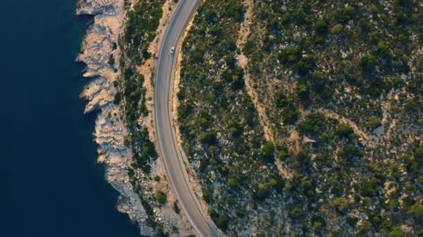 Αεροφωτογραφία του ορεινού δρόμου κοντά στην γαλαζοπράσινη θάλασσα το καλοκαίρι. — Αρχείο Βίντεο