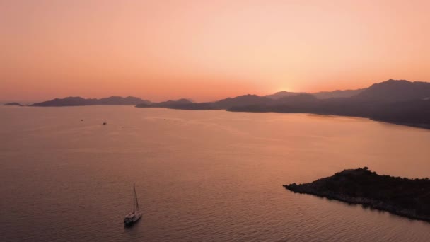 Vista aérea del cielo rojo al atardecer sobre el mar y las montañas. — Vídeo de stock