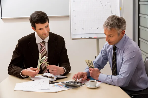 Businessmen share the profit. — Stock Photo, Image