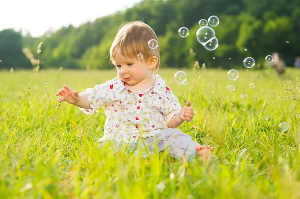 Babe spelen op het gazon. — Stockfoto