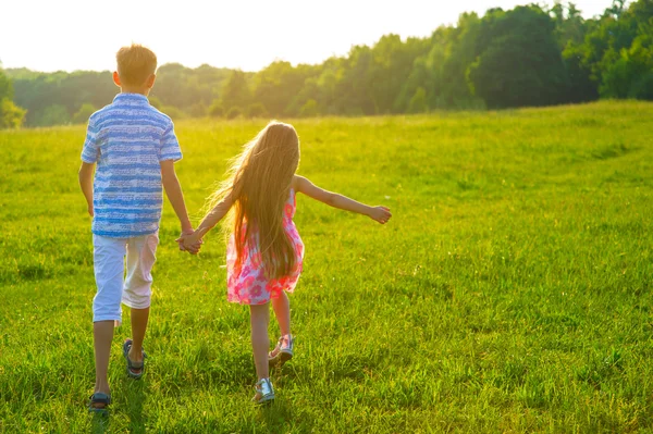 Niños caminando en una hermosa puesta de sol . —  Fotos de Stock