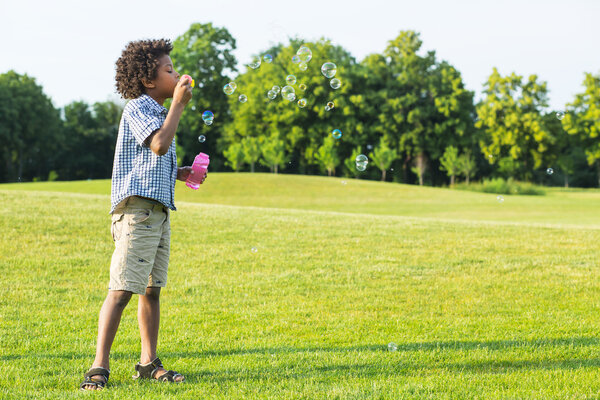 Cute boy is making bubbles.