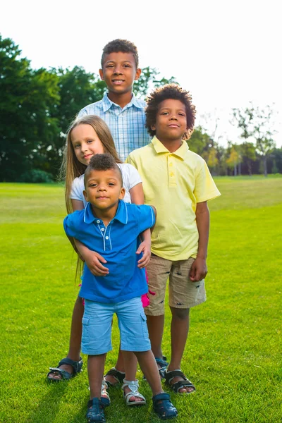 Four children are playing on the glade. — Stock fotografie