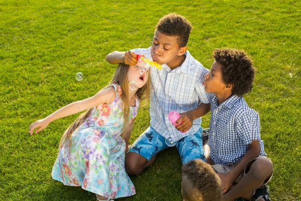 Vier kinderen spelen op de glade. — Stockfoto