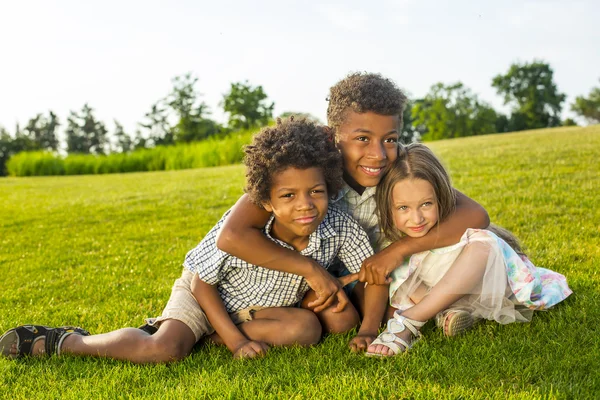 Three children are playing on the glade. — ストック写真