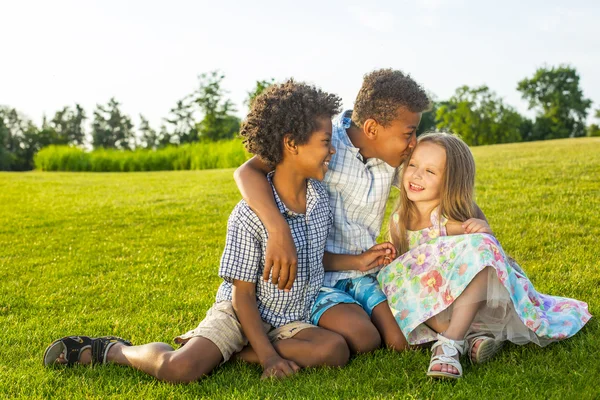 Three children are playing on the glade. — ストック写真