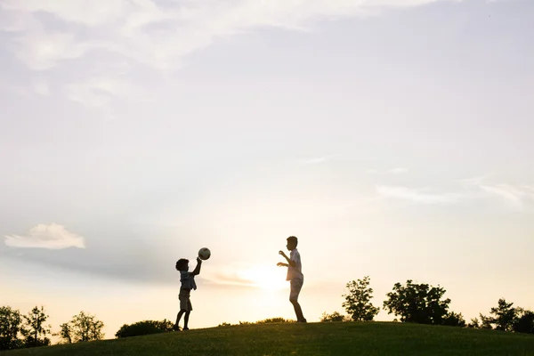 Два хлопці грають на заході сонця . — стокове фото