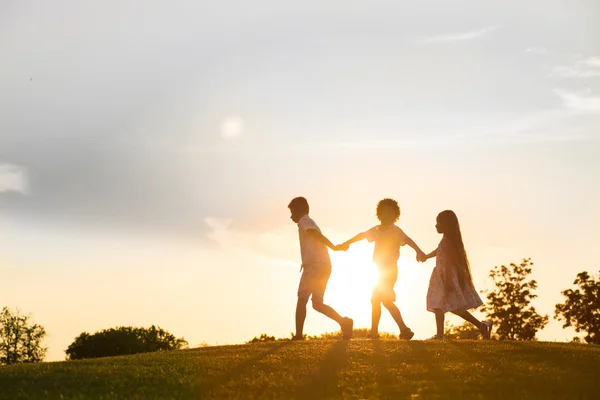 Three kids are playing on sunset. — Φωτογραφία Αρχείου