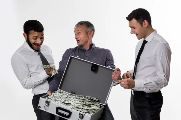 Young people with a suitcase full of money. — Stockfoto