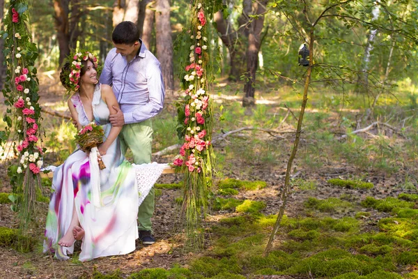Beautiful couple on flower swing. — Stock Photo, Image