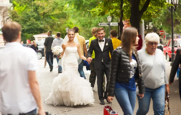 Newlyweds are walking on the street and smilling. Royalty Free Stock Images