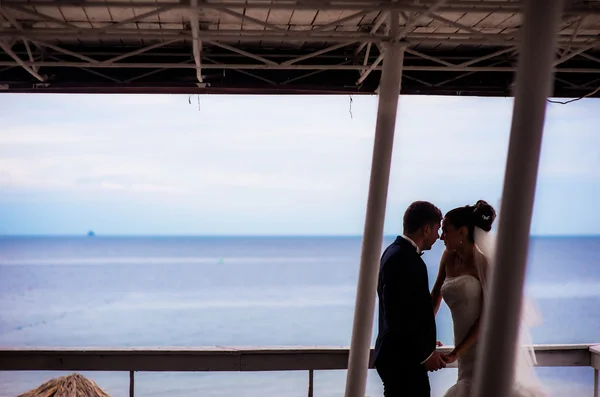 Sposi felici sotto il baldacchino in riva al mare . — Foto Stock